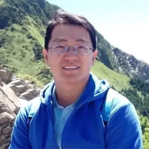 老王在山稜線前的側身照,背景是綠色山坡